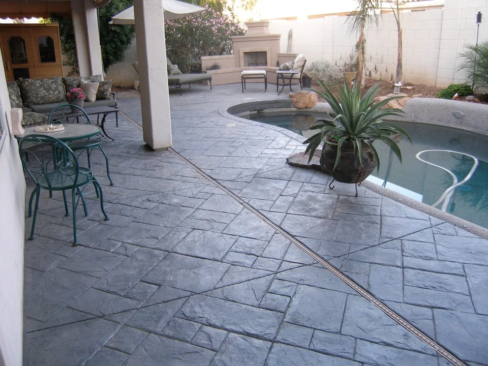 An open patio connects shaded seating with the poolside space.