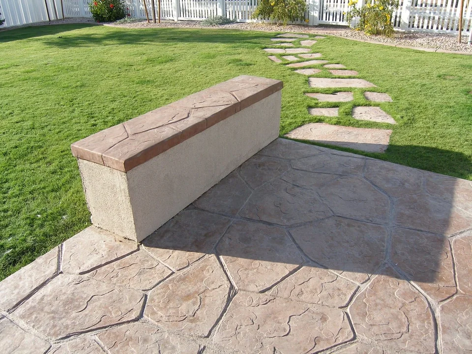 A low seating wall connects a paved sitting area with the lawn.
